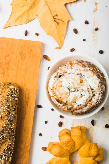 Foto gratuita pastelería cerca de hojas y pan