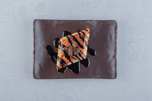 Pastelería dulce decorada con chocolate colocado en un plato oscuro