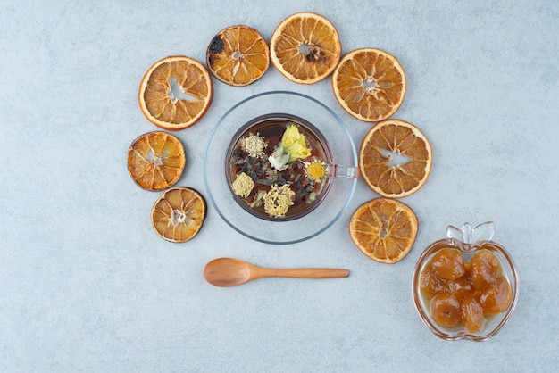 Pastelería dulce con naranja seca y taza de té de hierbas sobre fondo de mármol. Foto de alta calidad