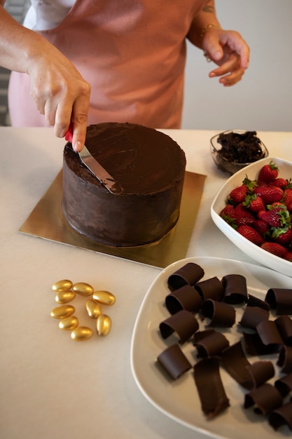Pastelería femenina con pastel de chocolate en la pastelería