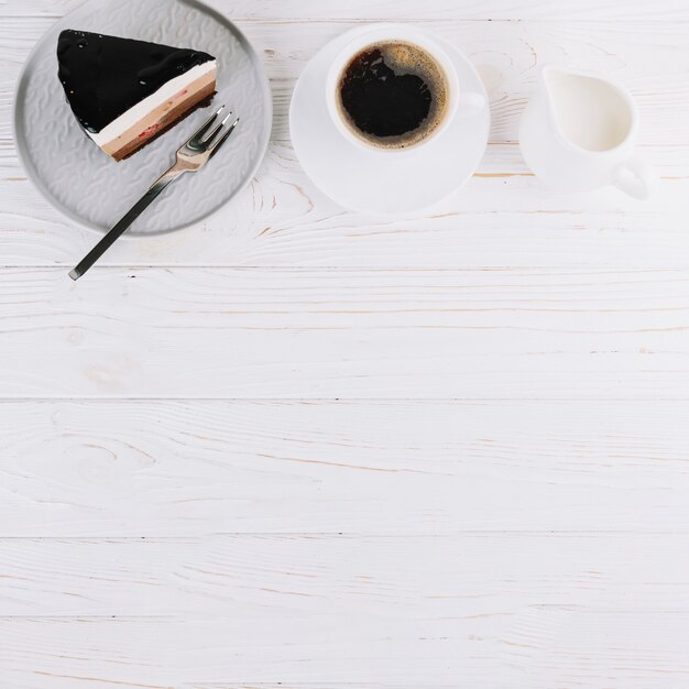 Pastelería fresca y taza de té para el desayuno en mesa de madera