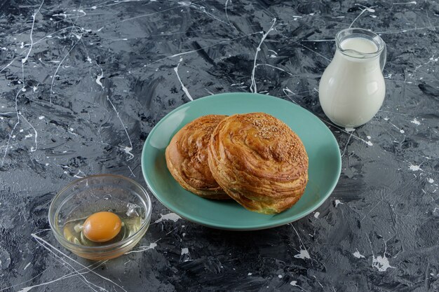 Pastelería nacional de Azerbaiyán con huevo de gallina crudo y una jarra de vidrio con leche fresca.