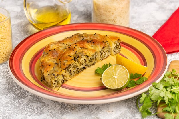 Pastelería de vista frontal con comida de masa deliciosa carne dentro de la placa con aceite de limón en el escritorio de luz blanca.