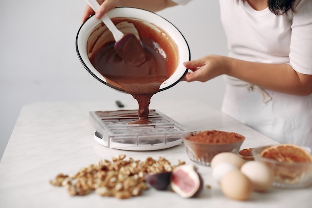 Pastelero mezcla los ingredientes. La señora está preparando el postre. La mujer hornea un pastel.