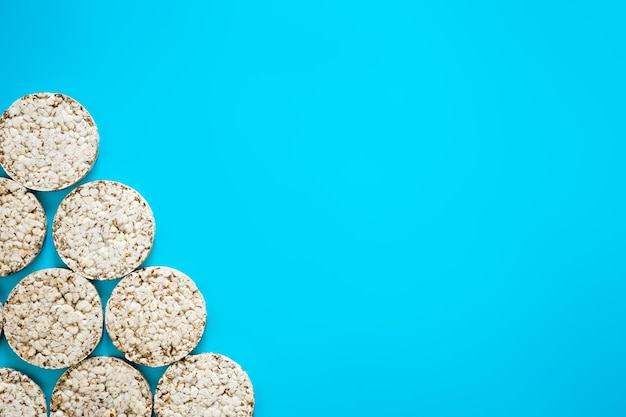 Foto gratuita pasteles de arroz inflado sobre fondo azul espacio de copia plana