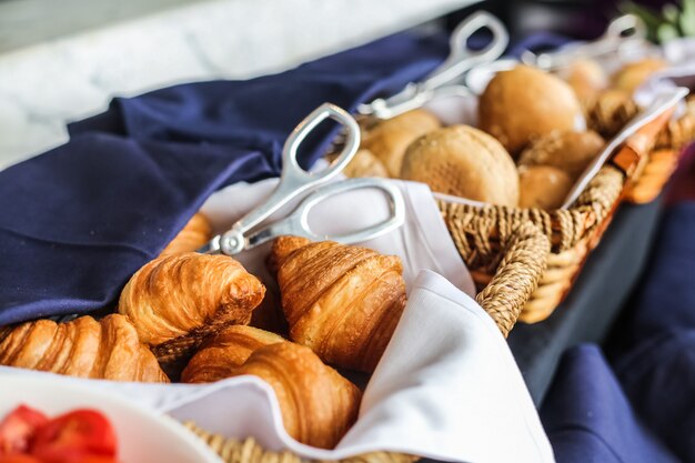 Pasteles en la cesta de mimbre croissant bollos vista lateral