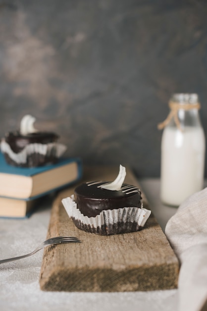 Pasteles de chocolate con tenedor en tablero de madera