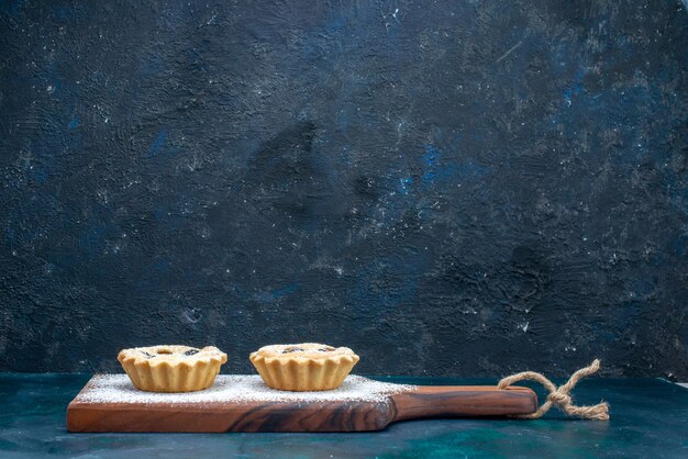 pasteles dulces con frutas sobre azul oscuro