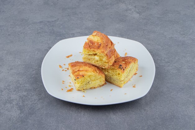 Pasteles frescos en rodajas en un plato blanco.