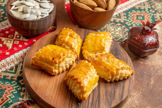 Pasteles de nueces dulces de vista frontal con nueces en mesa marrón