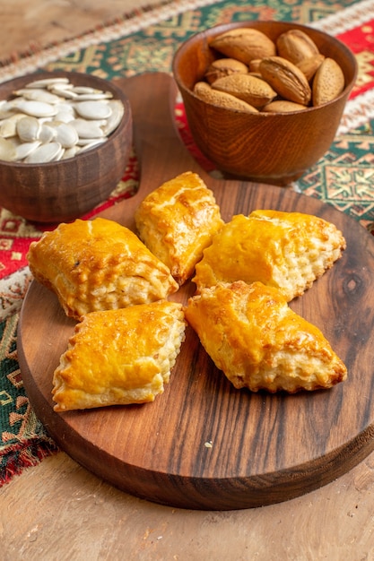 Pasteles de nueces dulces de vista frontal con nueces en mesa marrón