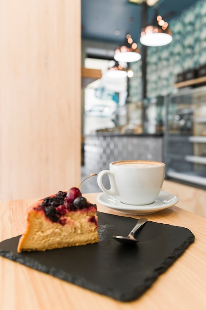 Pasteles recién horneados con taza de café en la mesa de madera