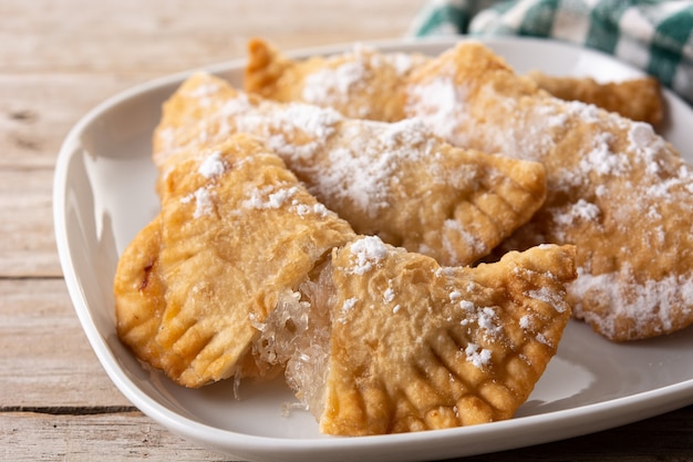 Pasteles rellenos dulces españoles llenos de cabello de ángel en la mesa de madera.