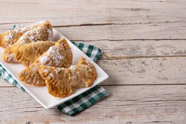 Pasteles rellenos dulces españoles llenos de cabello de ángel sobre mesa de madera