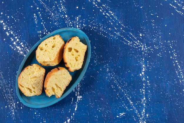 Pasteles en rodajas sabrosos frescos colocados en la placa azul