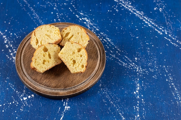 Foto gratuita pasteles en rodajas sabrosos frescos colocados en placa de madera