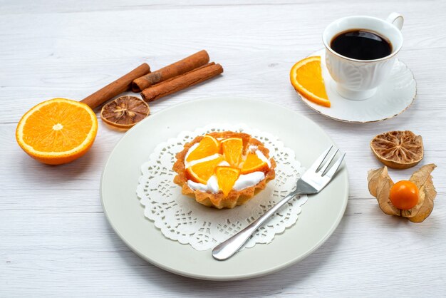 pastelito con crema y naranjas en rodajas junto con café y canela en una mesa de luz, pastel de frutas, galleta, azúcar dulce