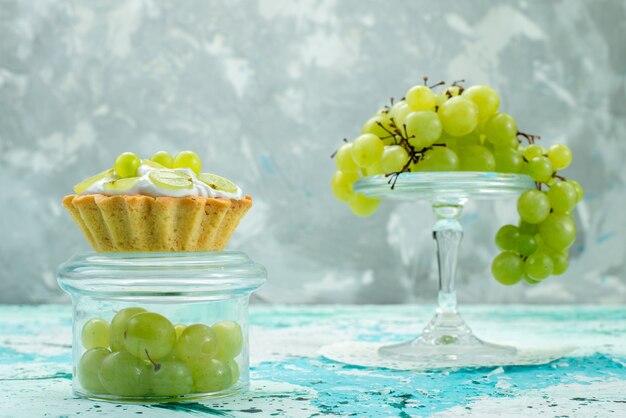pastelito con deliciosa crema y uvas verdes frescas y en rodajas aisladas en azul, pastel de frutas dulces horneado