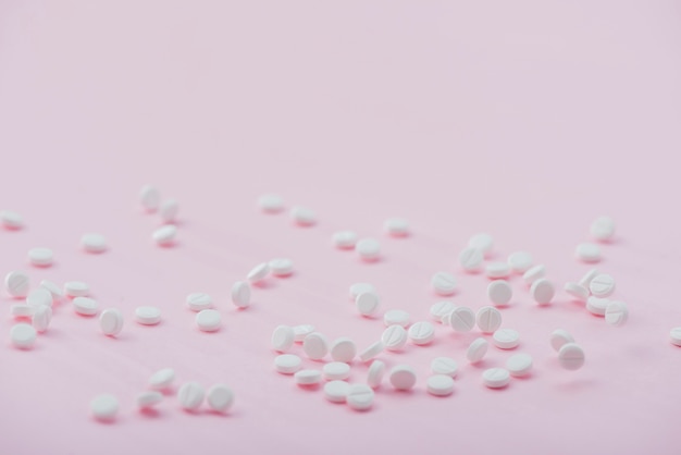 Foto gratuita pastillas de alto ángulo sobre fondo rosa