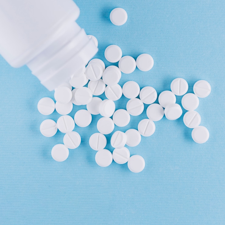 Foto gratuito pastillas blancas y botella de plástico