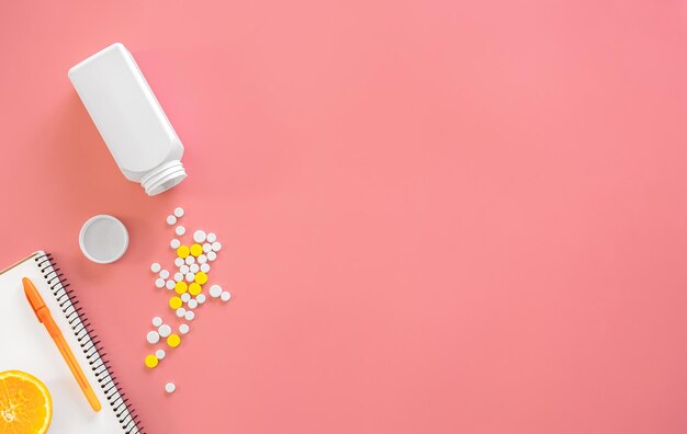 Pastillas dispersas sobre un fondo rosa plano