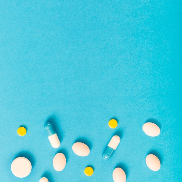 Foto gratuita pastillas que forman el borde inferior sobre fondo azul