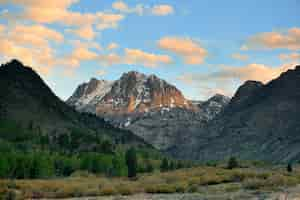 Foto gratuita pastizales y montañas nevadas con nubes en yosemite.