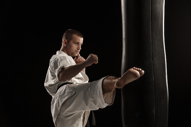 Patada redonda de karate en un saco de boxeo