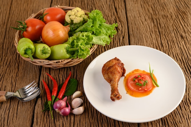 Patas de pollo frito en un plato blanco con salsa.