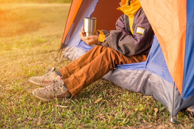 Patas visibles desde la carpa en el camping en fondo de madera salvaje