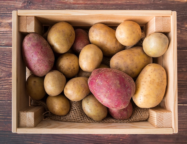 Patatas crudas en caja de madera