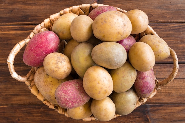 Patatas crudas en canasta de madera