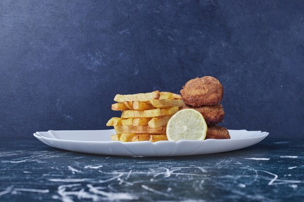 Patatas fritas con cotlets y limón.