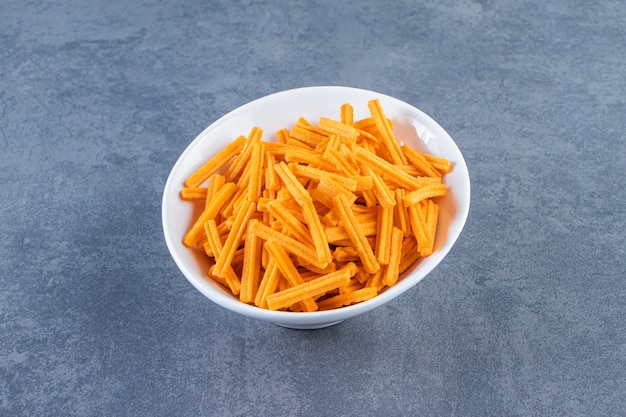 Patatas fritas dulces en un recipiente, sobre el fondo de mármol.