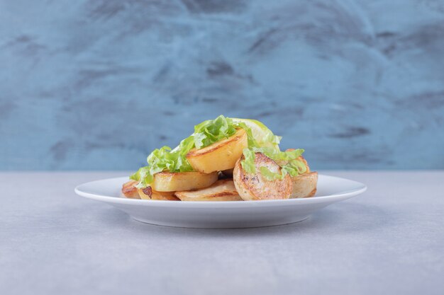 Patatas fritas con limón en un plato blanco.