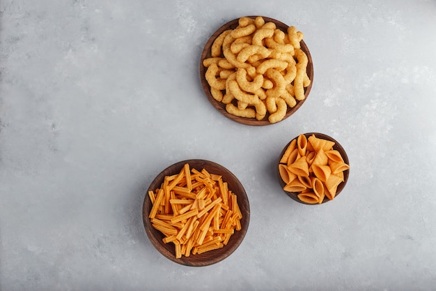 Patatas fritas y maíz en cuencos de madera.