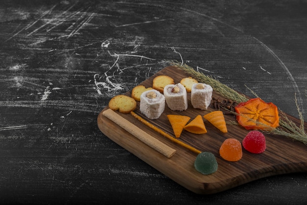 Patatas fritas con productos de pastelería en una bandeja de madera, ángulo de visión