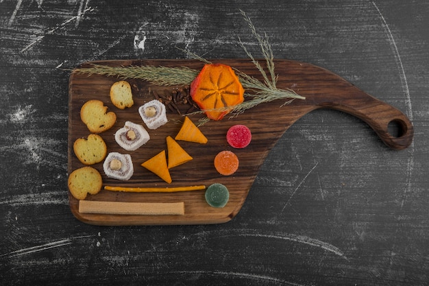 Patatas fritas con productos de pastelería en una bandeja de madera en el medio