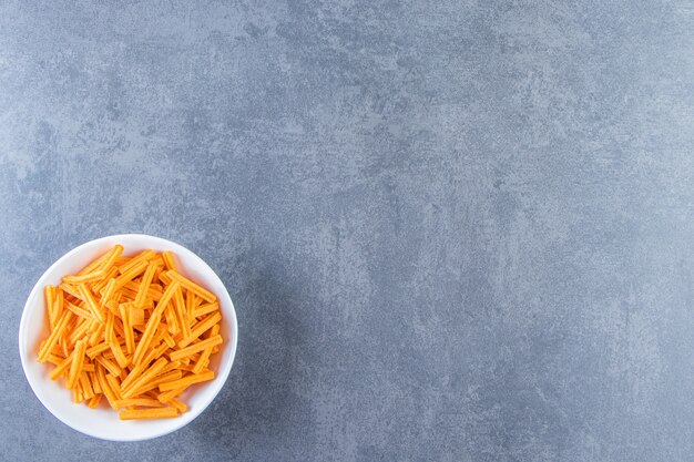 Patatas fritas en un recipiente sobre la superficie de mármol