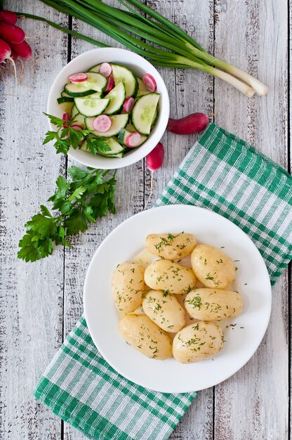 Patatas hervidas con mantequilla y eneldo en un plato blanco