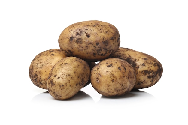 Patatas sucias sobre una superficie blanca