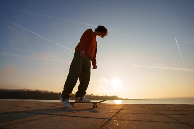 Foto gratuita patinador de tiro completo posando al atardecer