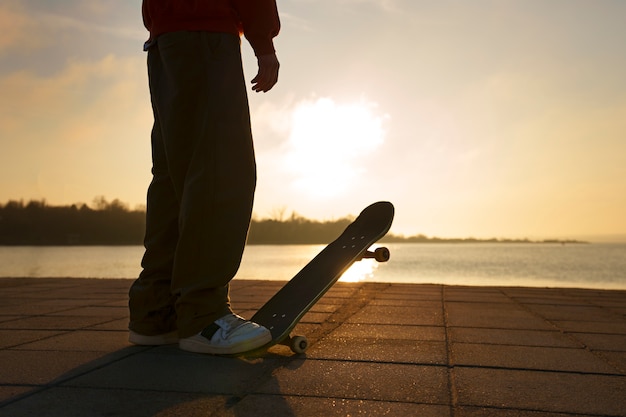 Foto gratuita patinador de vista lateral posando al atardecer