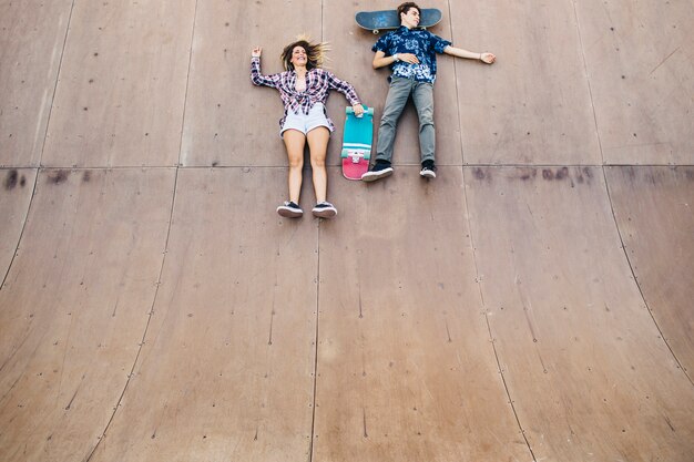 Patinadores jóvenes tumbados en el halfpipe