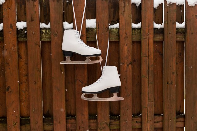 Patines colgando de la valla de madera