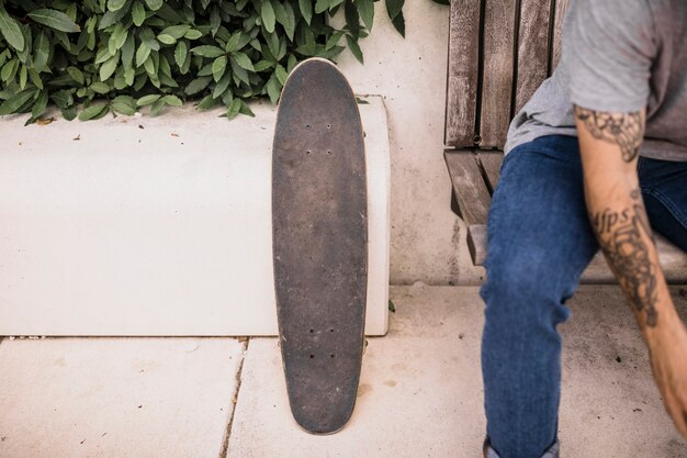 Patineta de madera cerca del niño sentado en el banco