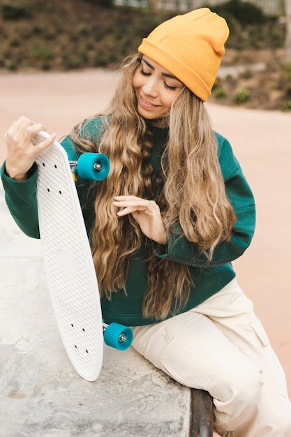 Foto gratuita patineta de verificación femenina sonriente