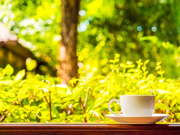 Patio exterior con hermosa vista a la naturaleza y taza de café blanco.
