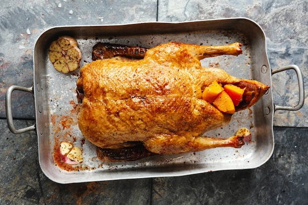 Foto gratuita pato asado al horno con verduras en sartén sobre fondo de madera vieja. vista superior.