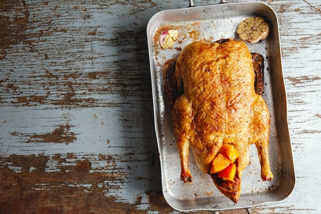 Foto gratuita pato asado al horno con verduras en sartén sobre fondo de madera vieja. vista superior.